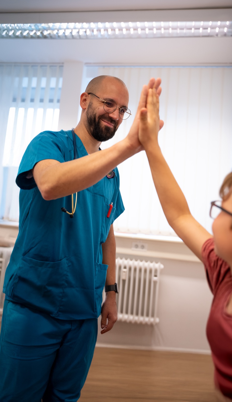 Facharzt Pädiatrie der GMKB gibt einem Kind High-Five im Medizinzentrum Bonn